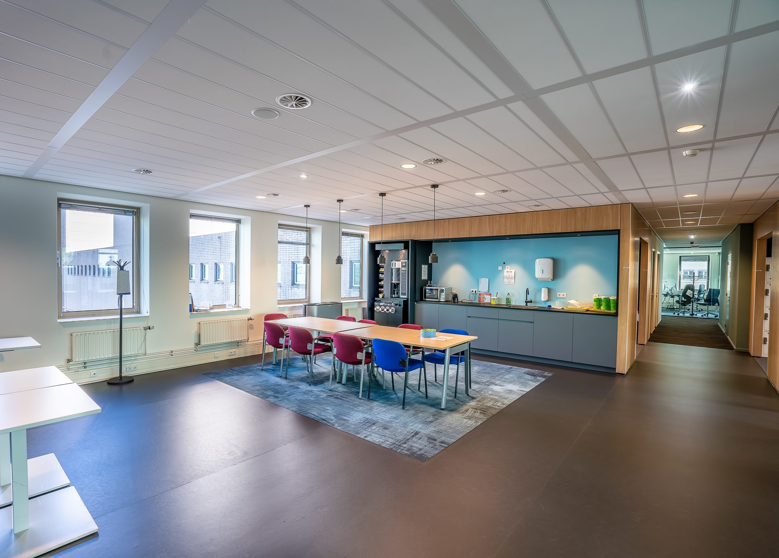 Interior of the kitchen area of a modern office with a long wooden table and chairs interior of the kitchen area of a modern office with a long wooden table and chairs